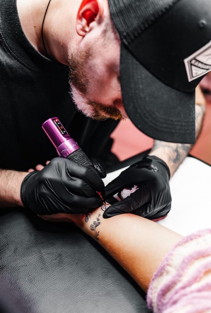 Student volgt tattoo opleiding in studio tijdens praktijkles leren tatoeëren